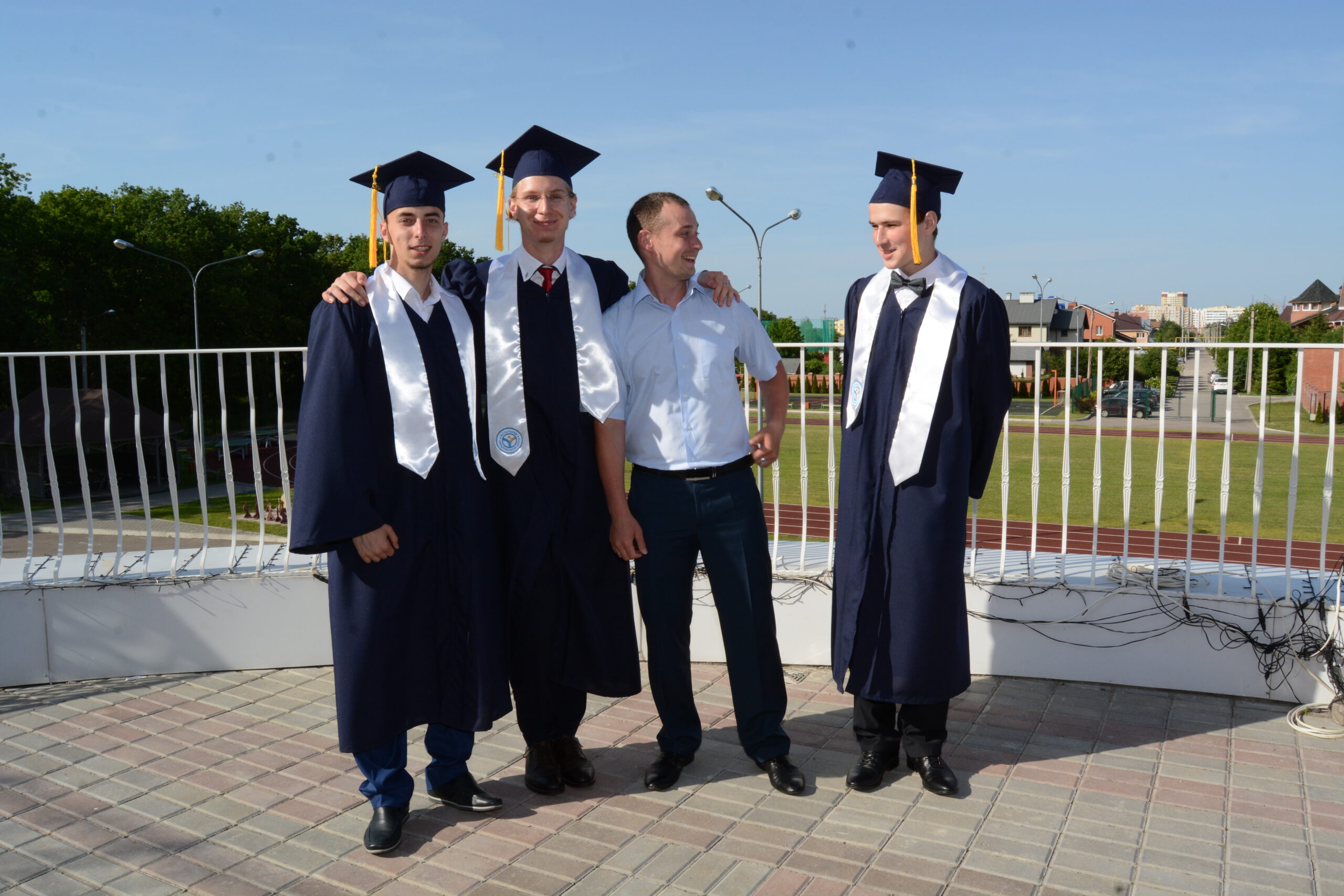 Выпускники Международной школы Источник с учителем на церемонии выпуска.