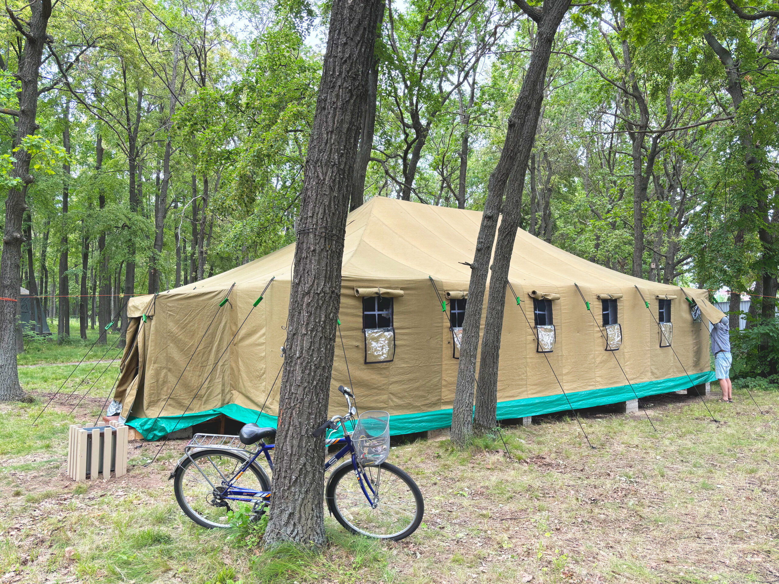 Large tent for overnight camping among trees in the outdoor camp