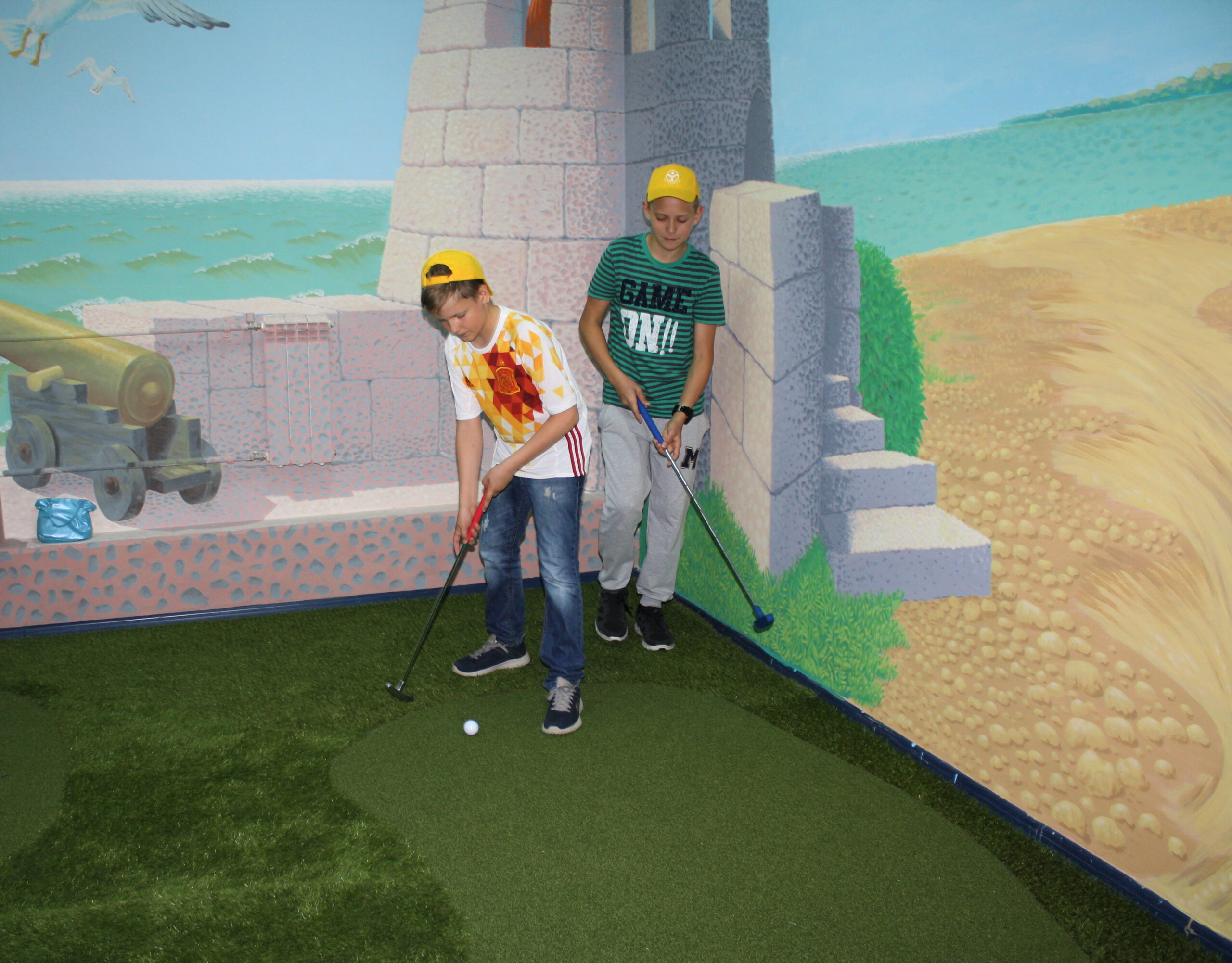 Children playing mini-golf in the camp game room