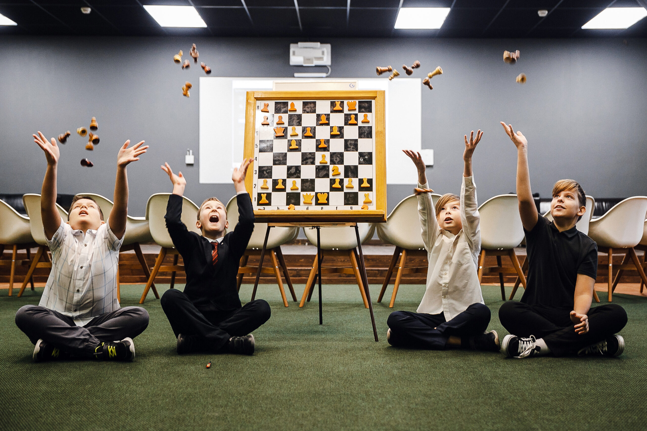 Children playing chess and tossing pieces during a school lesson