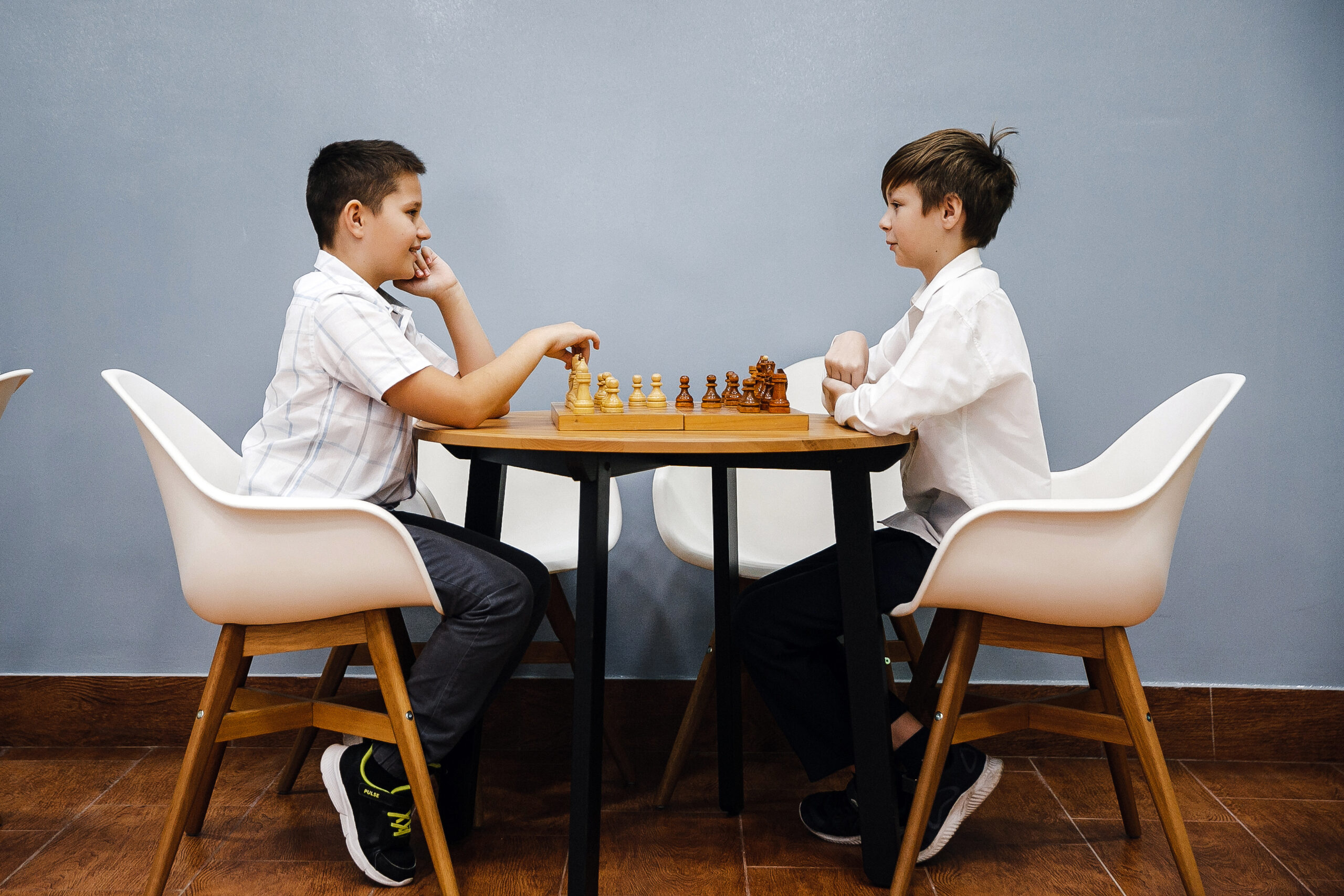 Two students playing chess at a table in school