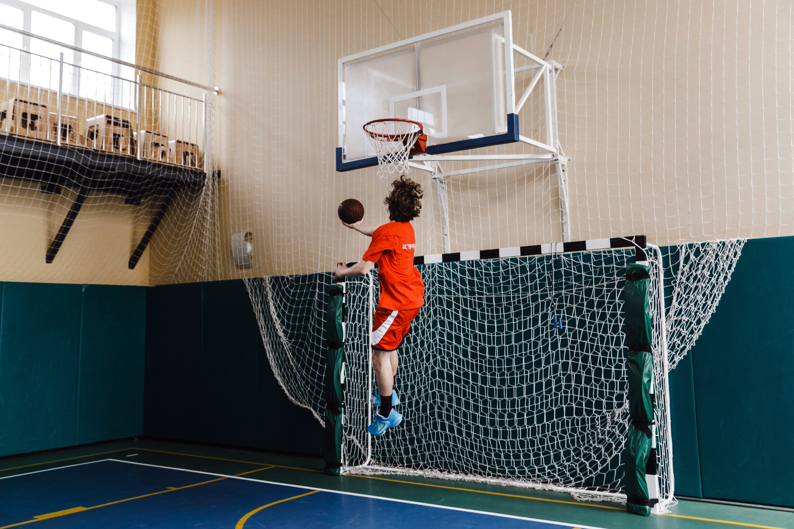 Student making a jump shot in the basketball hoop during gym class