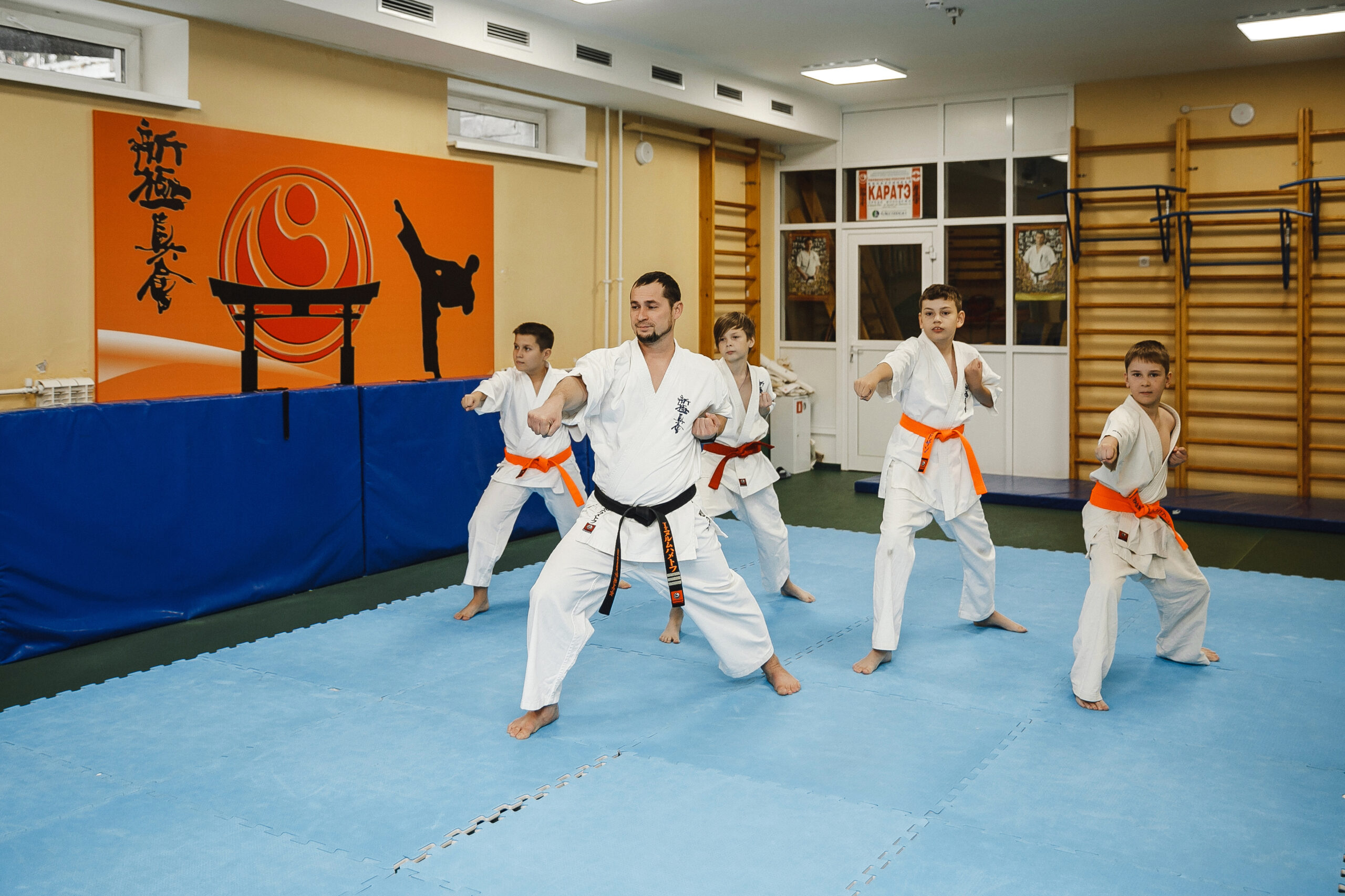 Karate lesson with instructor and students on gym floor